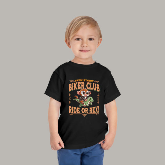 Toddler tee design featuring a cartoon tarsier in a leather jacket riding a green dinosaur with the text “Prehistoric Biker Club – Ride or Rex!” for a fun and adventurous Filipino-inspired design.