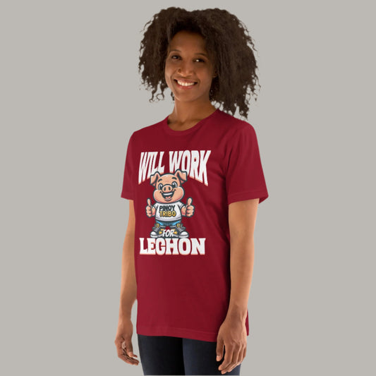 A fun and playful "Will Work for Lechon" graphic tee featuring a cartoon pig mascot wearing a "Pinoy Tribo" shirt, sneakers, and giving thumbs-up, with bold text celebrating Filipino food culture.