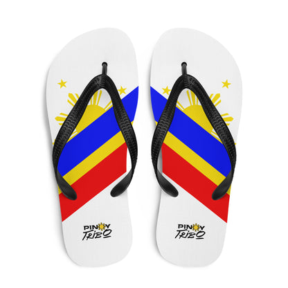 Flip flops featuring a bold Philippine flag-inspired design with diagonal blue, red, and yellow stripes, black straps, and the PINOY TRIBO™ logo printed at the heel.