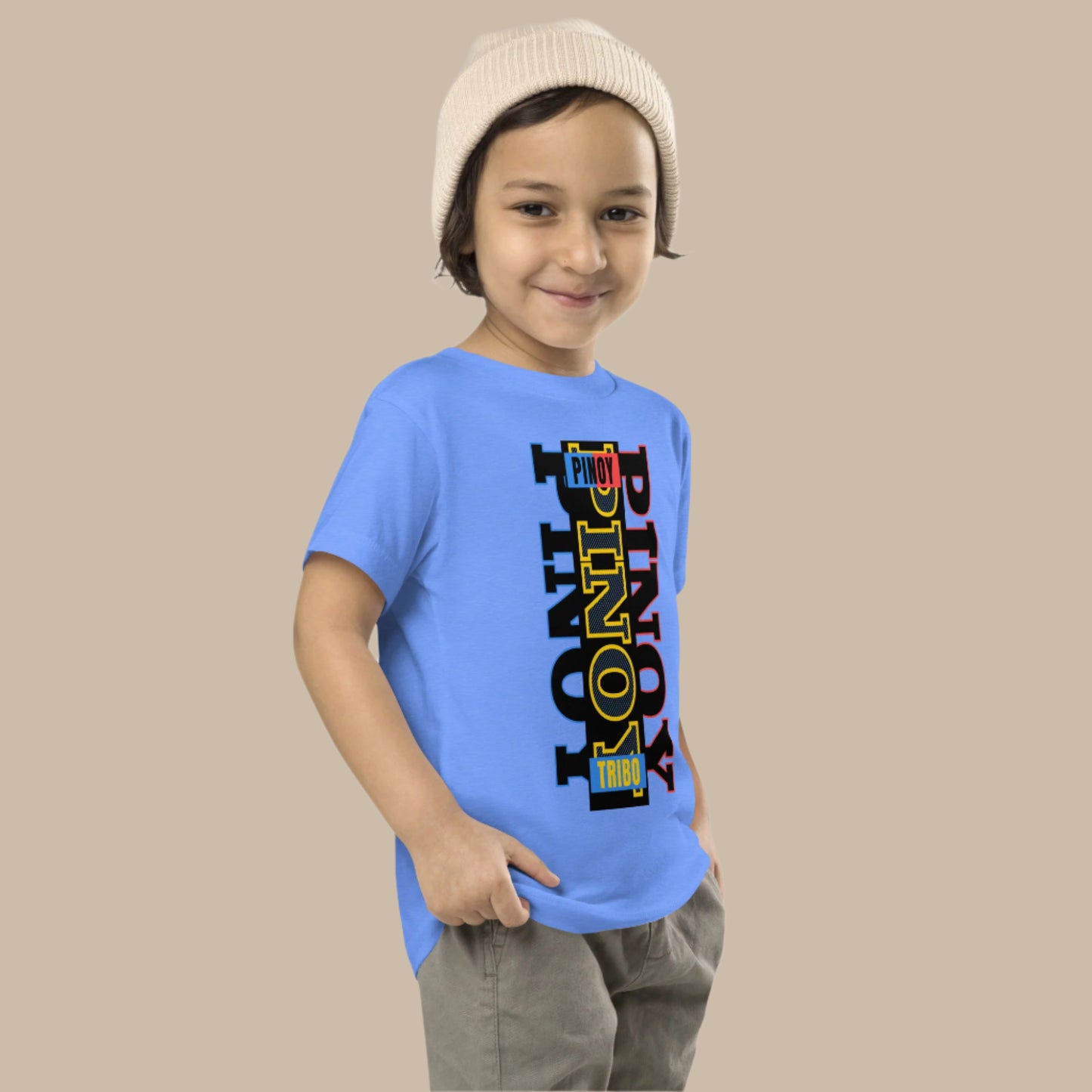 Toddler tee design with bold vertical text spelling “PINOY” in red, yellow, and blue with block-style accents, inspired by the Philippine flag.