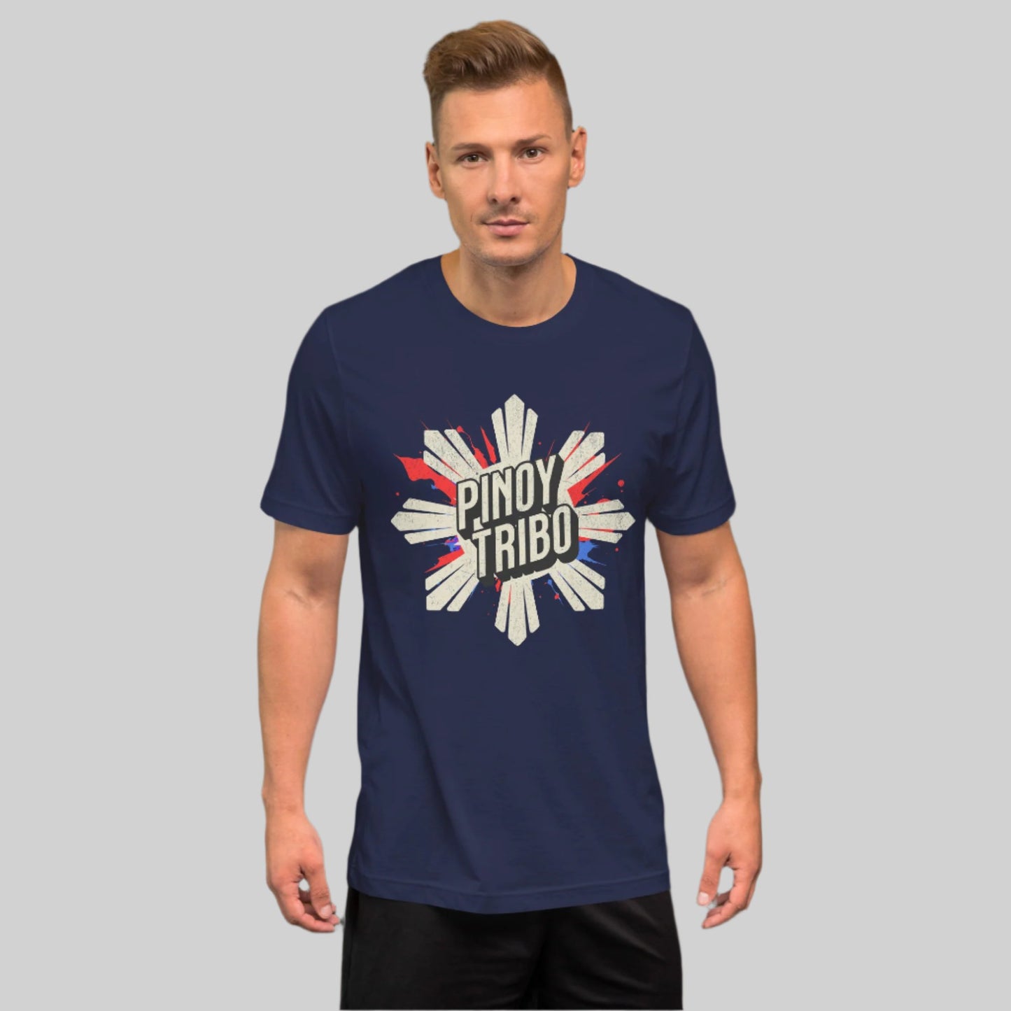 A distressed-style graphic t-shirt featuring a bold sunburst design with red and blue paint splashes, and the text "Pinoy Tribo," symbolizing Filipino pride and culture.