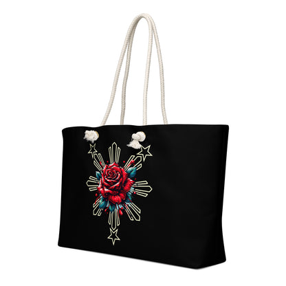 Weekender bag with a rose and sunburst three-star Filipino design on a black background with rope handles.