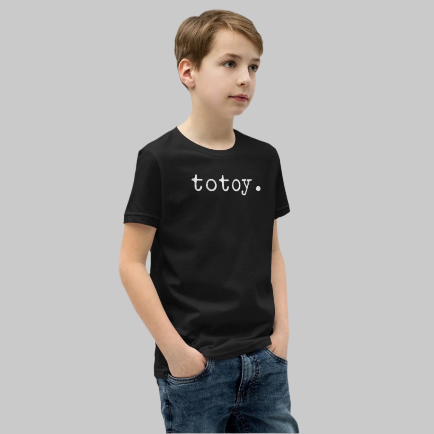 Minimalist white text “totoy.” in a typewriter-style font on a youth t-shirt design.