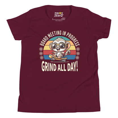 Cute cartoon Philippine tarsier wearing sunglasses, riding a skateboard with a retro striped background and the text “Board Meeting in Progress” and “Grind All Day!” on a youth t-shirt design.